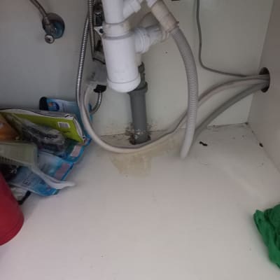 צנרת מתחת לכיור עם חיבורים וצינורות פלסטיק