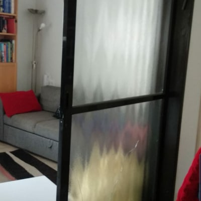 דלת זכוכית עם סדקים במסגרת מתכת שחורה