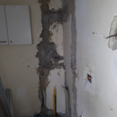 קיר עם טיח מתקלף וחוטי חשמל חשופים