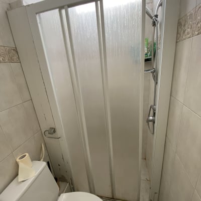 מקלחון עם דלת זכוכית ומקלחת יד