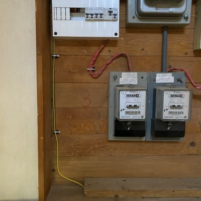 לוח חשמל עם חוטים ומונים על קיר עץ