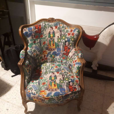 כורסה מרופדת בבד צבעוני עם דמויות ופרחים