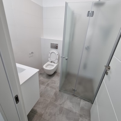 חדר אמבטיה עם מקלחון ודלת זכוכית