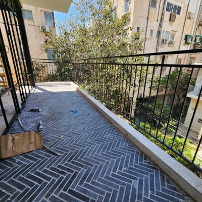 מרפסת עם מעקה ברזל וכלי עבודה על הרצפה