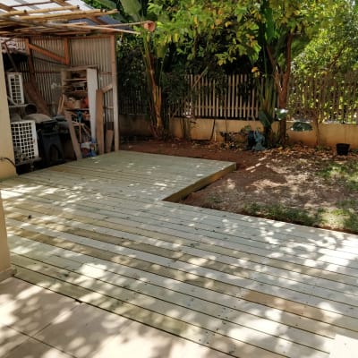 דק עץ בגינה עם מחסן כלים בצד