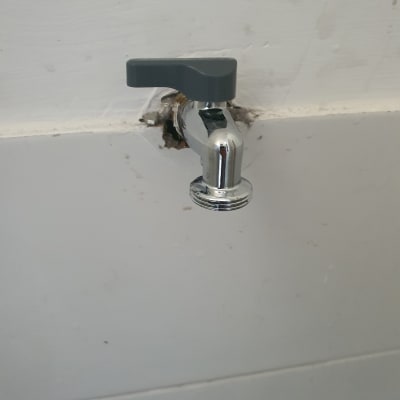 ברז מים מותקן על קיר לבן