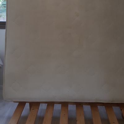 מזרן עומד על מיטה עם כתמים נראים לעין