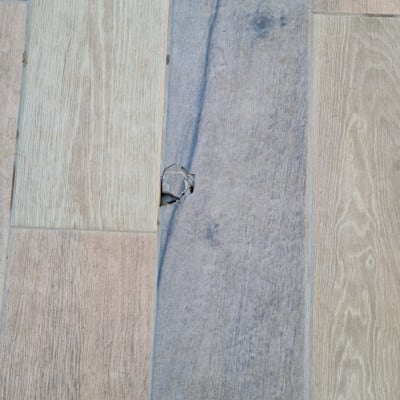 רצפת עץ עם חור קטן בלוח אחד