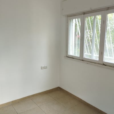 קיר לבן צבוע ליד חלון עם סורגים