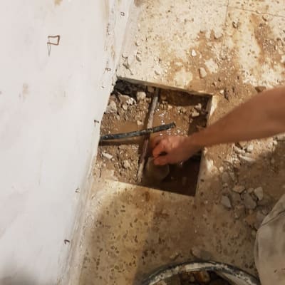 יד מתקנת צינור דולף ברצפה