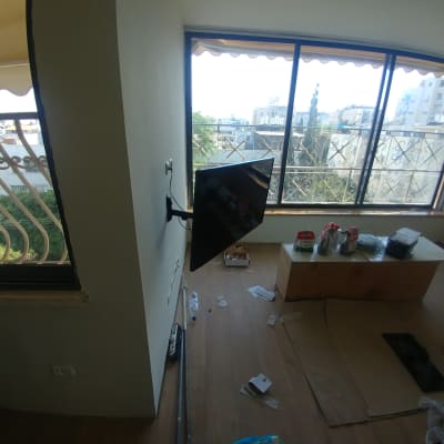 טלוויזיה מותקנת על הקיר, כלים וחומרים על שולחן