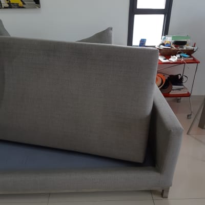 ספה אפורה עם כריות על רצפה בהירה