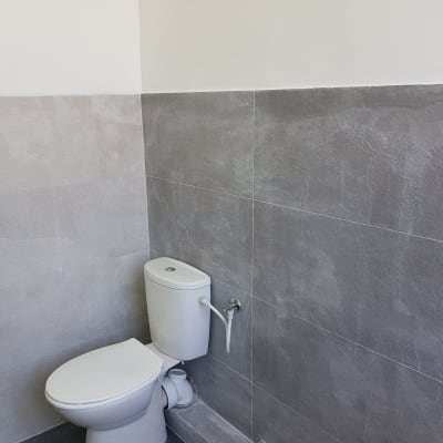 שירותים עם אריחים אפורים על הקיר