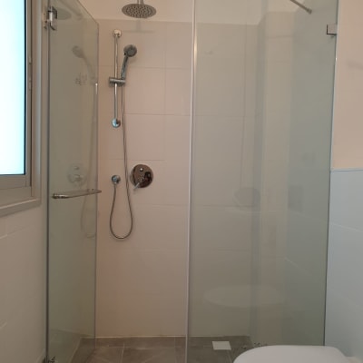 מקלחת עם ראש גשם ודלת זכוכית שקופה