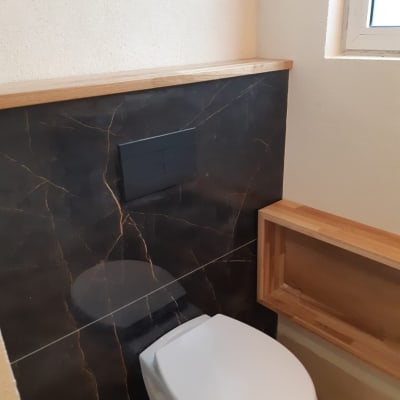 שירותים עם חיפוי שיש כהה ומדף עץ