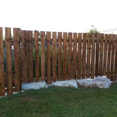 גדר עץ חומה עם דשא ירוק מלפנים