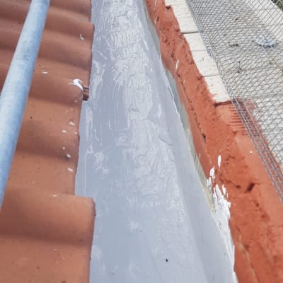 איטום גג עם חומר אפור בין רעפים