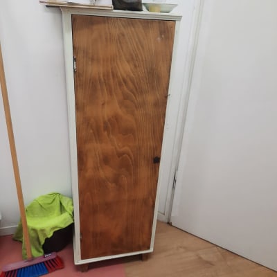 ארון עץ קטן עם מטאטא ומגב לידו