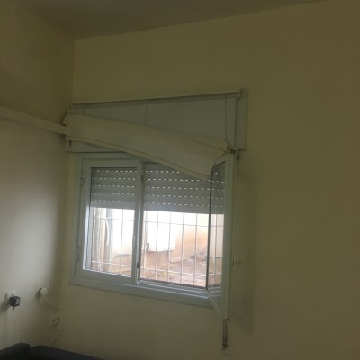 קיר צבוע בצבע בהיר ליד חלון עם תריסים