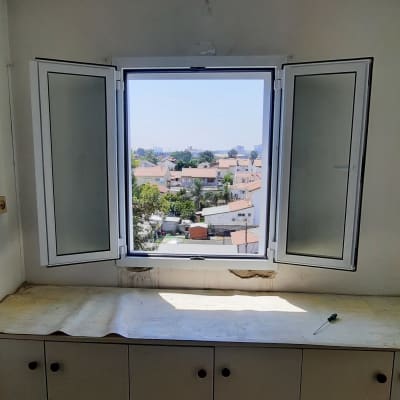 חלון אלומיניום פתוח עם נוף עירוני