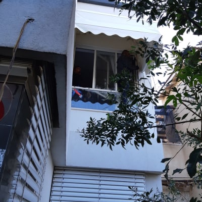 סוכך לבן מותקן מעל חלון בקומה עליונה