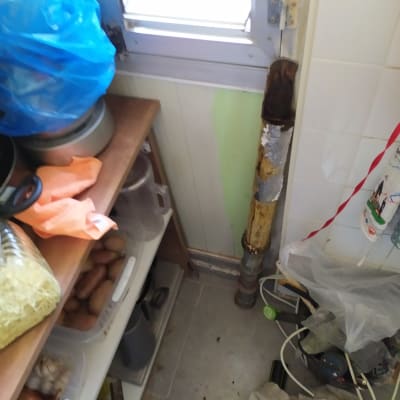 צינור חלוד עם בידוד מתקלף ליד חלון