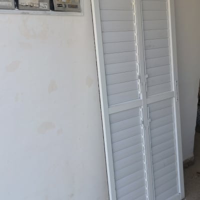 תריסים לבנים עומדים על הרצפה ליד קיר