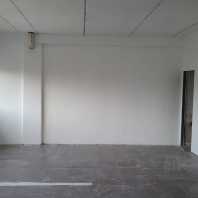 חדר עם קירות לבנים ורצפה אפורה