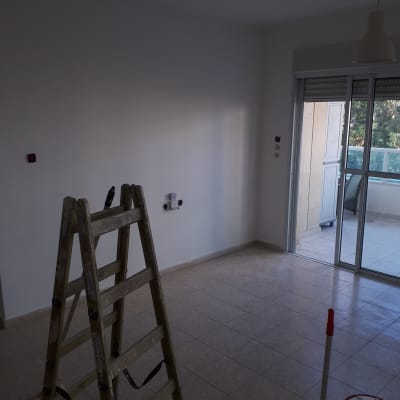 סולם ומכסה צבע בחדר ריק לצביעה