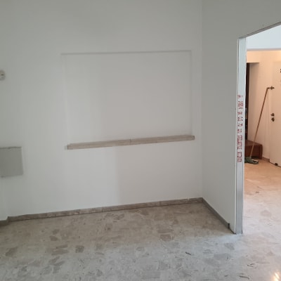 חדר ריק עם קירות לבנים ורצפת שיש