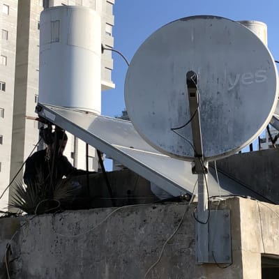 צלחת לוויין על גג עם כבלים חשופים