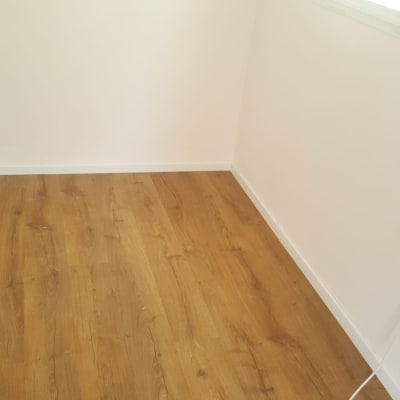 רצפת פרקט עץ בחדר עם קירות לבנים