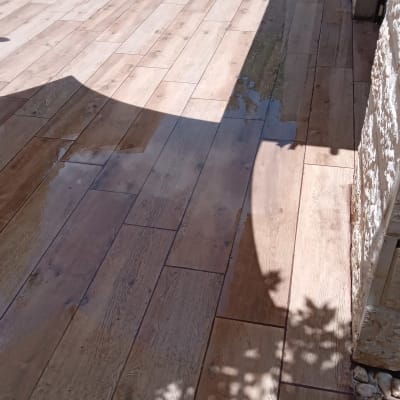 רצפת דק עץ רטובה עם צינור מים ירוק