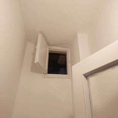 קירות ותקרה צבועים בלבן עם חלון פתוח