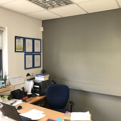 קיר צבוע בגוון אפור במשרד עם מסגרות כחולות