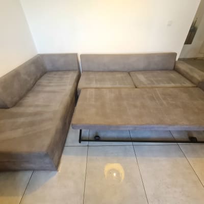 ספה אפורה עם סימני ניקוי על הריפוד