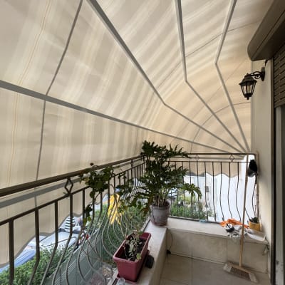 סוכך בד מפוספס על מרפסת עם צמחים