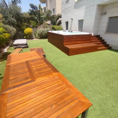 שולחן עץ על דשא סינתטי ליד ג