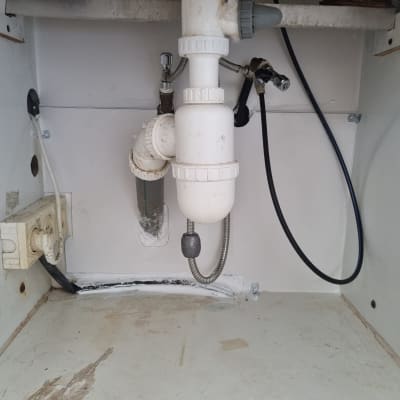 צנרת מתחת לכיור עם חיבורים ואביזרים