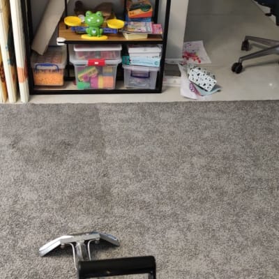 מכשיר ניקוי שטיחים על שטיח אפור בחדר ילדים