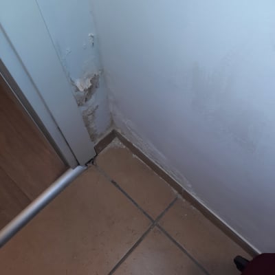 קיר עם סימני רטיבות והתקלפות צבע בפינה