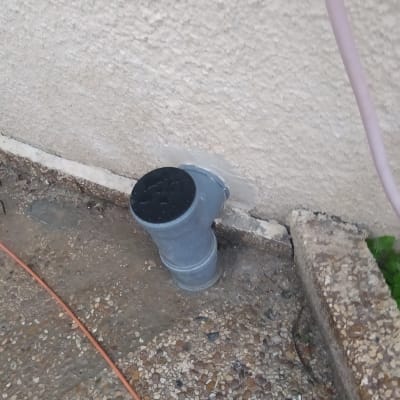 צינור פלסטיק אפור מחובר לקיר חיצוני