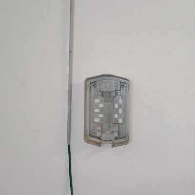 תיבת חיבורים פתוחה עם כבל ירוק על קיר