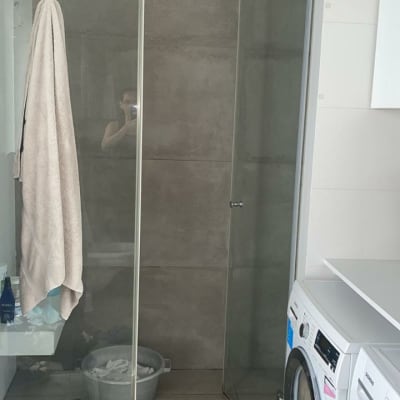 מקלחת עם מגבת תלויה ודלי על הרצפה