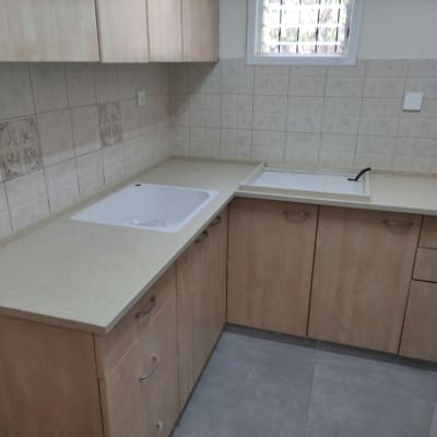 משטח שיש במטבח עם כיור לבן וברז שחור