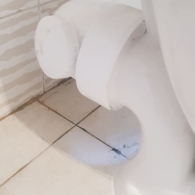 חיבור צינור לבן לאסלה על רצפת קרמיקה