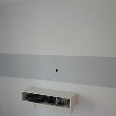 קיר צבוע בלבן ואפור עם מדף תחתון