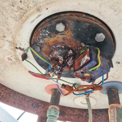 חוטי חשמל צבעוניים מחוברים למכשיר חלוד