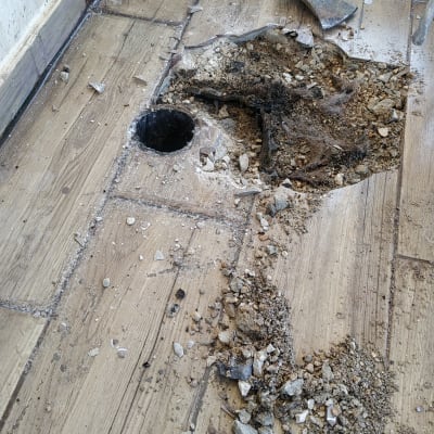 חפירה ברצפה עם כלים ואבנים מפוזרות