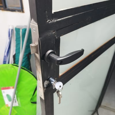 דלת מתכת עם ידית ומפתח במנעול